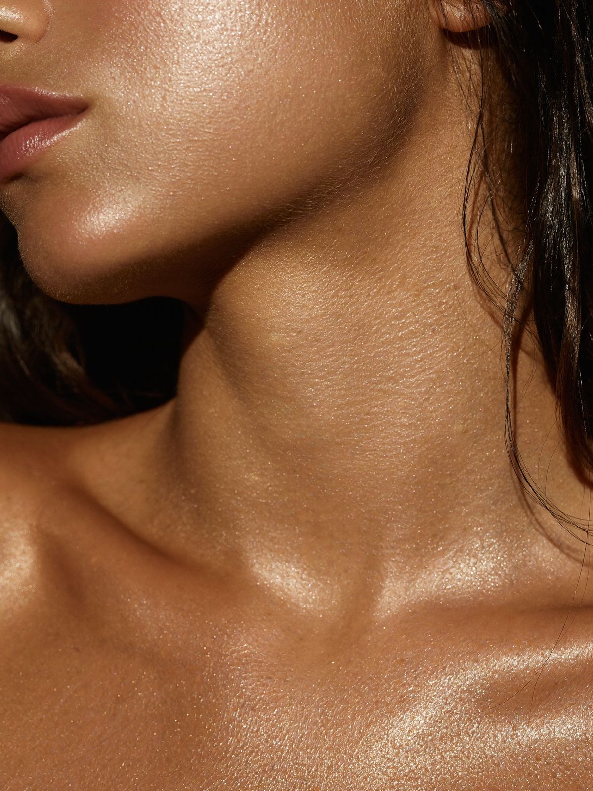 Close-up of glowing, bronzed skin in warm window light